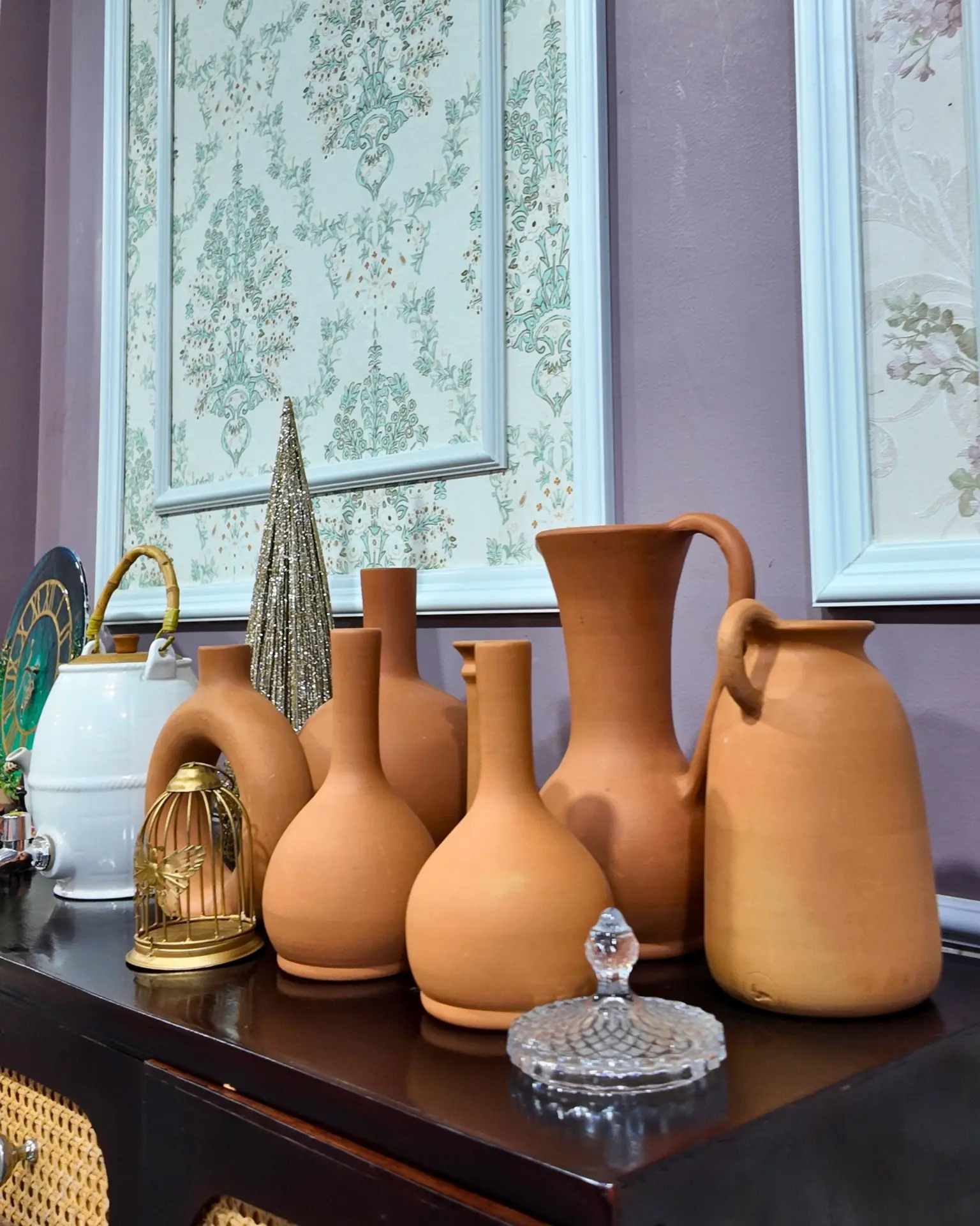 Terracotta vases and decorative pieces arranged on a wooden sideboard